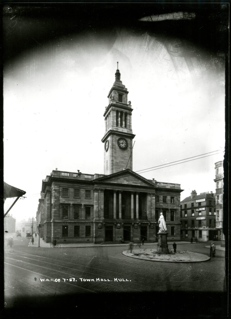 Black and white photo taken in 1922 in front of the Guildhall (known in 1922 as the Town Hall). The time ball is on top of the tower. The street is free of traffic but tramlines are embedded in the road. 